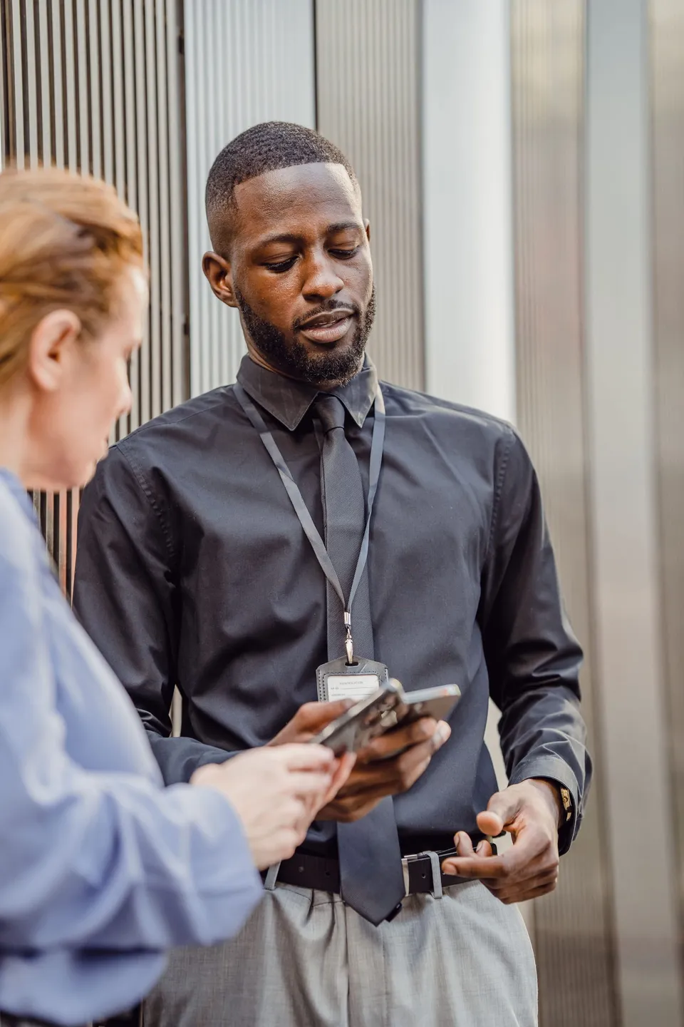 Agent de sécurité portant un badge d’identification, échangeant avec une cliente