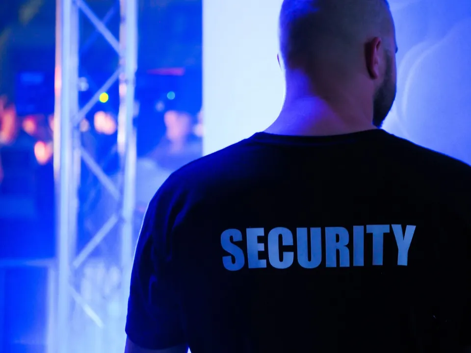 Agent de sécurité de dos, t-shirt SECURITY, lors d’un événement de nuit