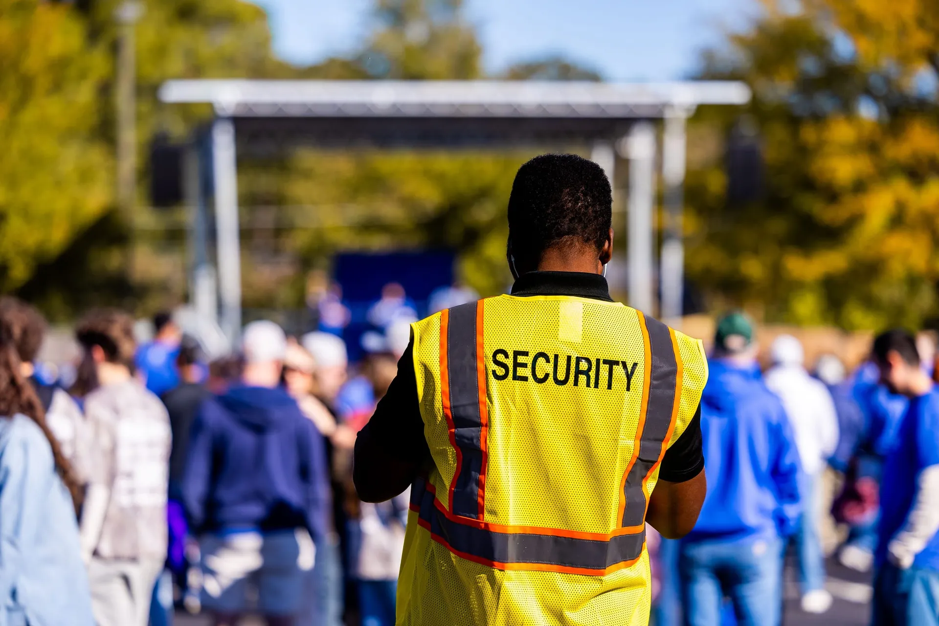 Agent de sécurité événementiel, gilet SECURITY, face à la foule d’un concert en plein air